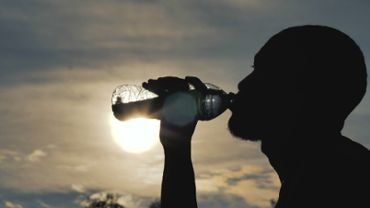 Silhouette of man drinking water