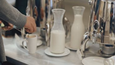 Breakfast bar or coffee bar with a woman preparing tea