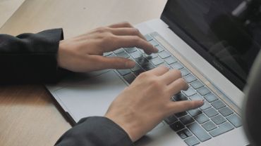 Typing on a laptop, close up