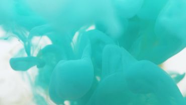 Ink swirling in green tones underwater