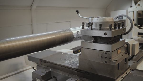 Lathe cutting a cylinder