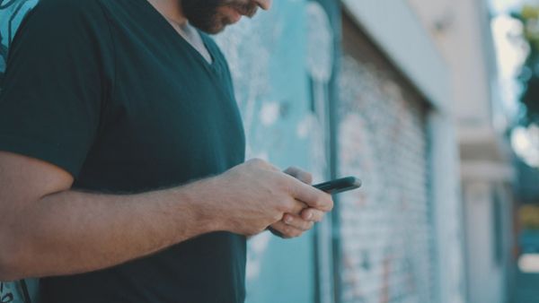 A person in the street messaging on a smartphone