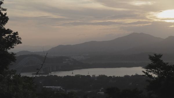 Time lapse of a landscape of a river with a bridge next to a city