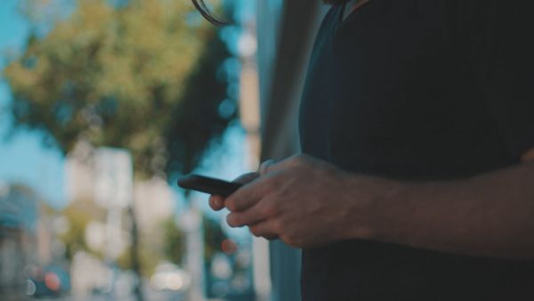 A person in the street messaging on a smartphone