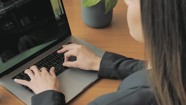 Woman writing on a laptop