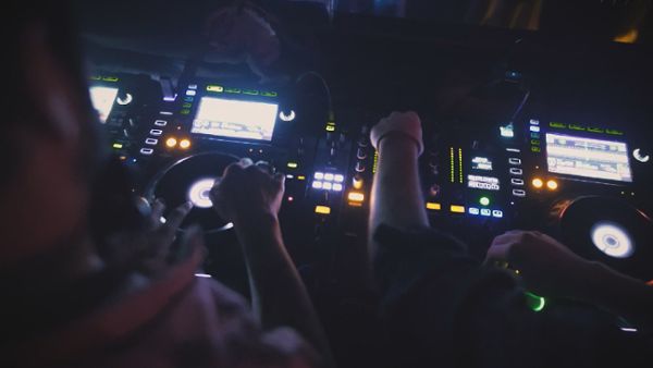 Two DJs mixing music at a nightclub